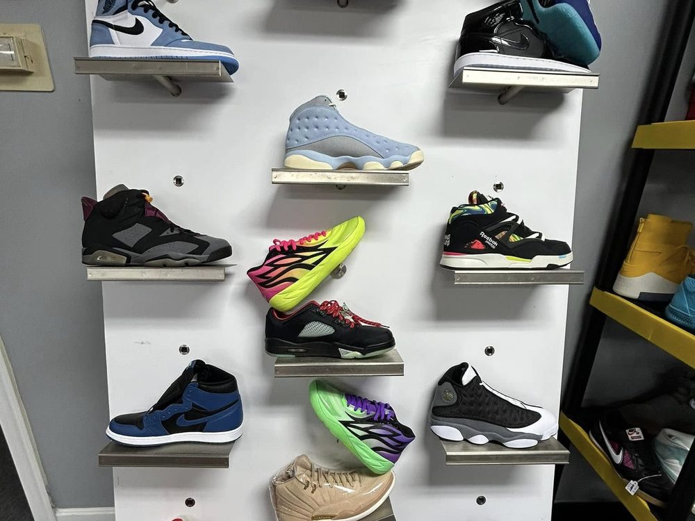 Sneaker display wall with Jordans, Dunks and Reeboks on floating shelves